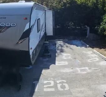 Leo Carrillo site 126, 360 photo: large travel trailer backed onto the pad, people nearby blurred